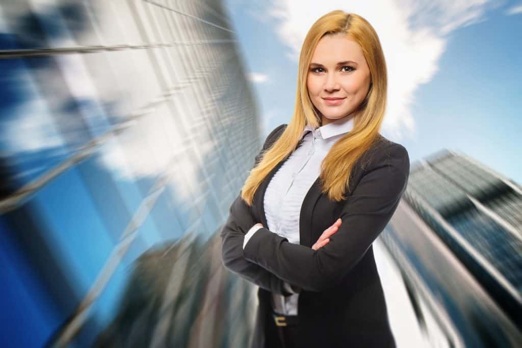 A businesswoman posing confidently before 40 in front of a building, exuding professionalism and financial expertise.