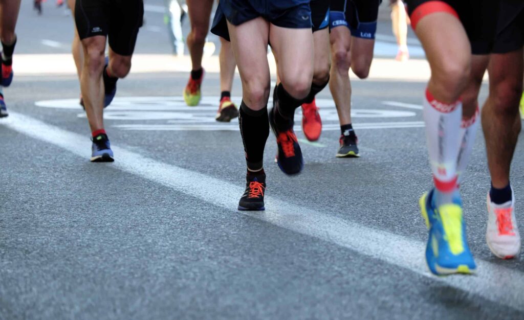 Legs and Feet of Runners in a Race. One Wearing Compression Socks