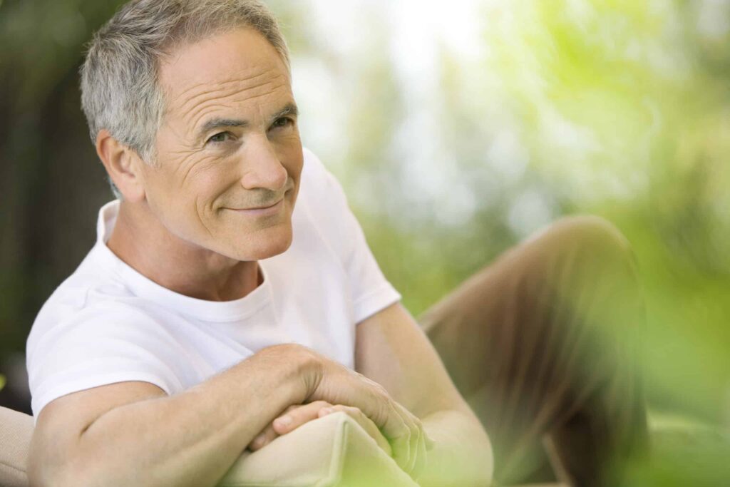 A man smiling with his arms crossed.