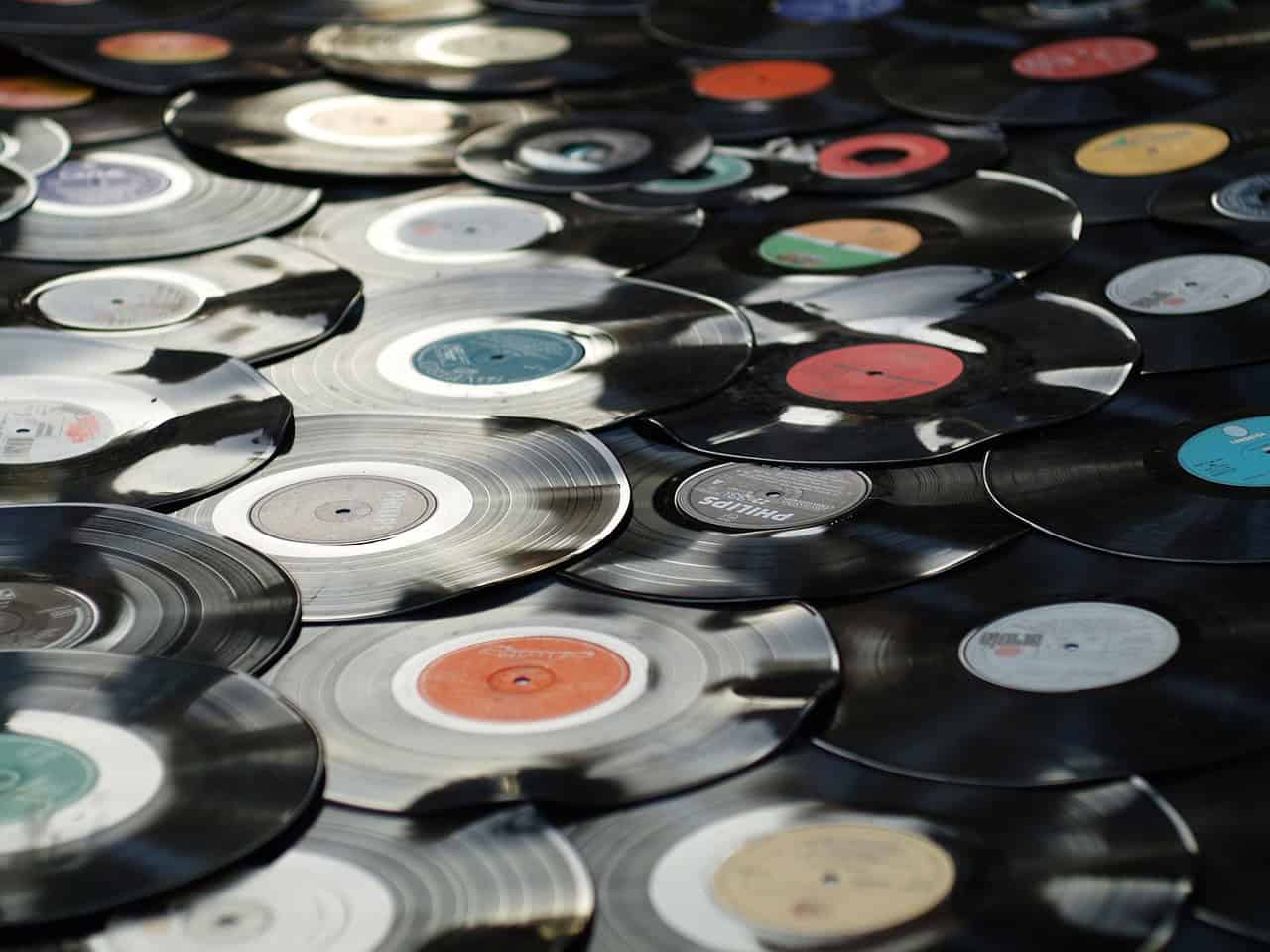 A scattered collection of vinyl records, each with a different colored label, lies on a surface, echoing the charm of things that are obsolete.