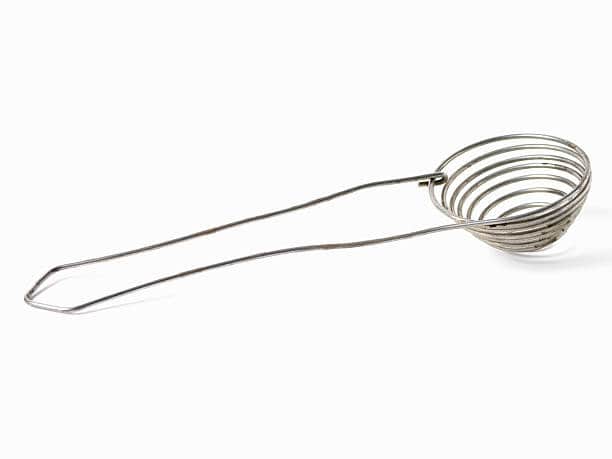 A metal wire egg separator with a spiral design and a long handle on a white background.