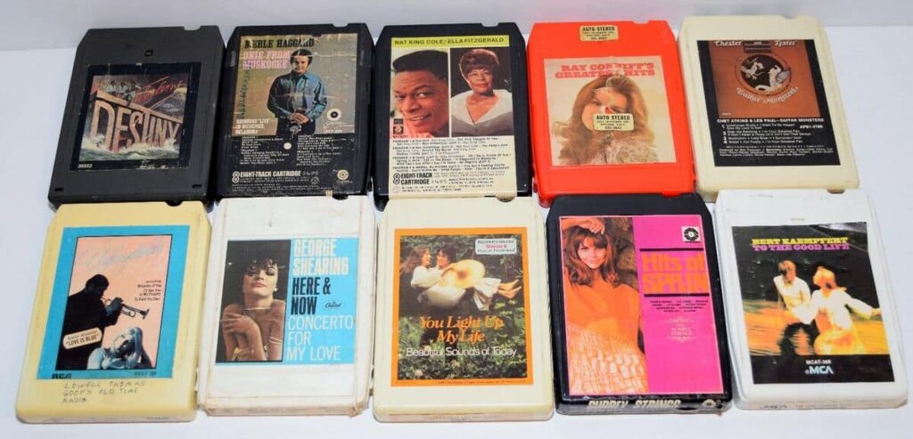 A collection of eleven vintage 8-track tapes from various artists, featuring album covers and track listings, arranged in a grid.