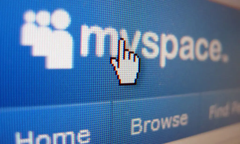 A close-up of a computer screen displaying the MySpace website logo with a pointer hand cursor icon hovering over it. The menu options "Home" and "Browse" are partially visible below.