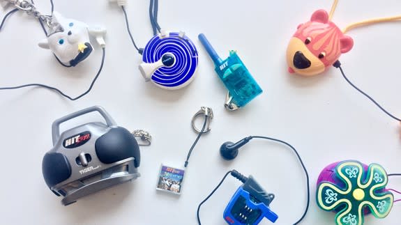 A collection of various child-friendly electronic devices and gadgets, including headphones, a walkie-talkie, a small radio, and animal-themed items, arranged on a white surface.