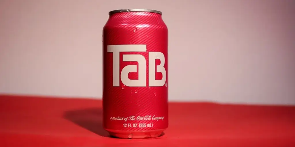 A red 12 fl. oz. can of Tab diet cola is displayed against a red background.