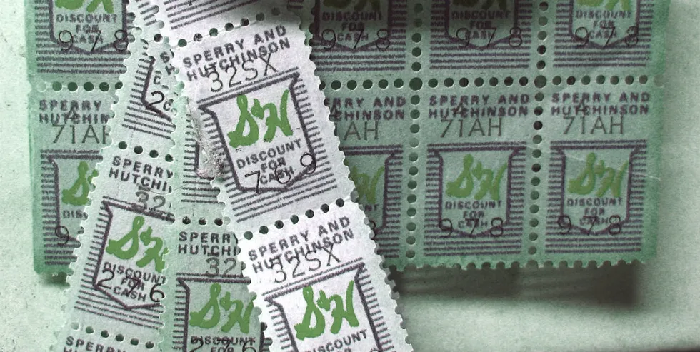 A collection of green Sperry and Hutchinson (S&H) Green Stamps, with several loose stamps overlapping a sheet of stamps, all bearing text and a logo.
