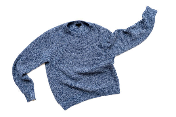 A blue knitted sweater with long sleeves is spread out on a white background.