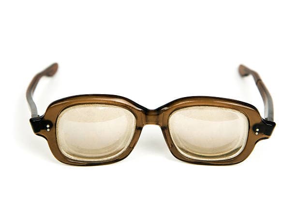 Brown-framed plastic vintage glasses with thick lenses on a white background.