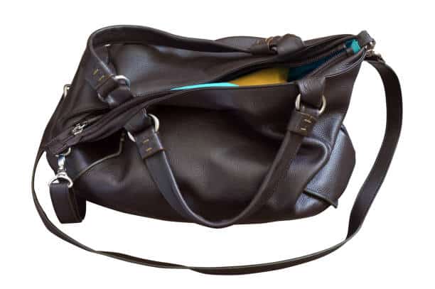 A dark brown leather handbag with multiple straps and an open top, revealing a hint of a yellow item inside.