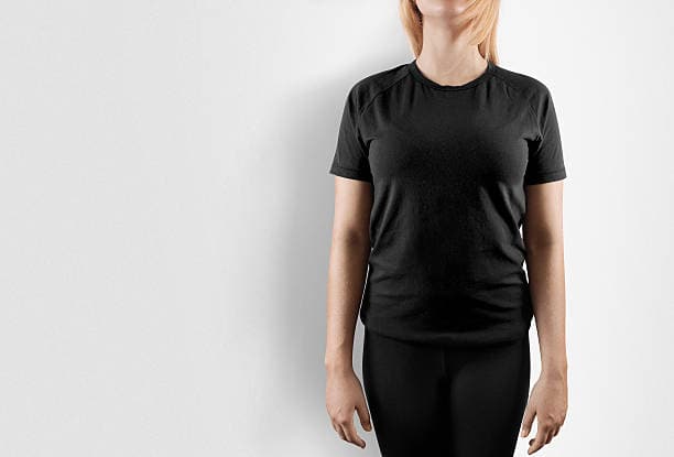 A person in a black t-shirt and pants stands against a white background. Their head is cropped out of the image.