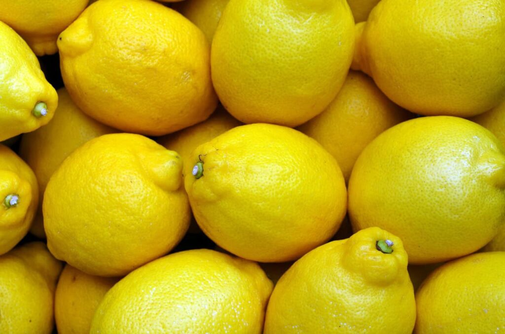 A pile of fresh yellow lemons closely packed together.