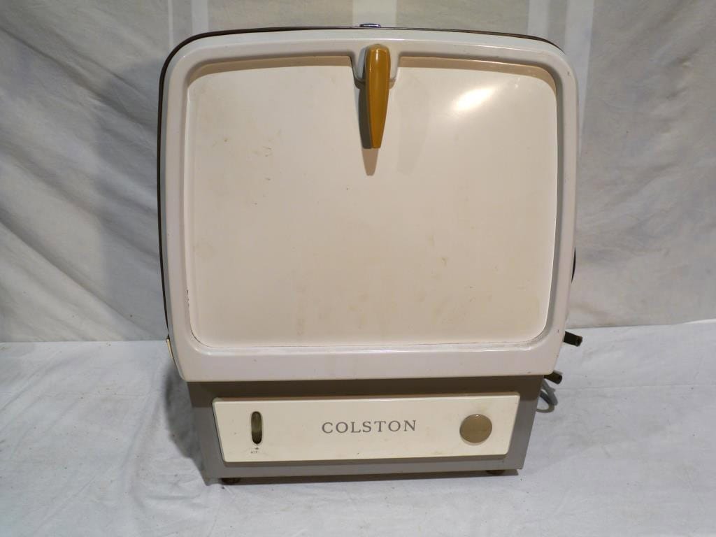 A vintage Colston washing machine with a square design and a lid featuring a yellow handle.