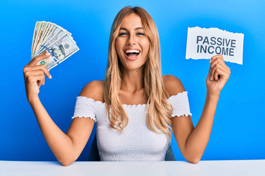 A woman smiles holding cash in one hand and a sign reading "PASSIVE INCOME" in the other, against a blue background.