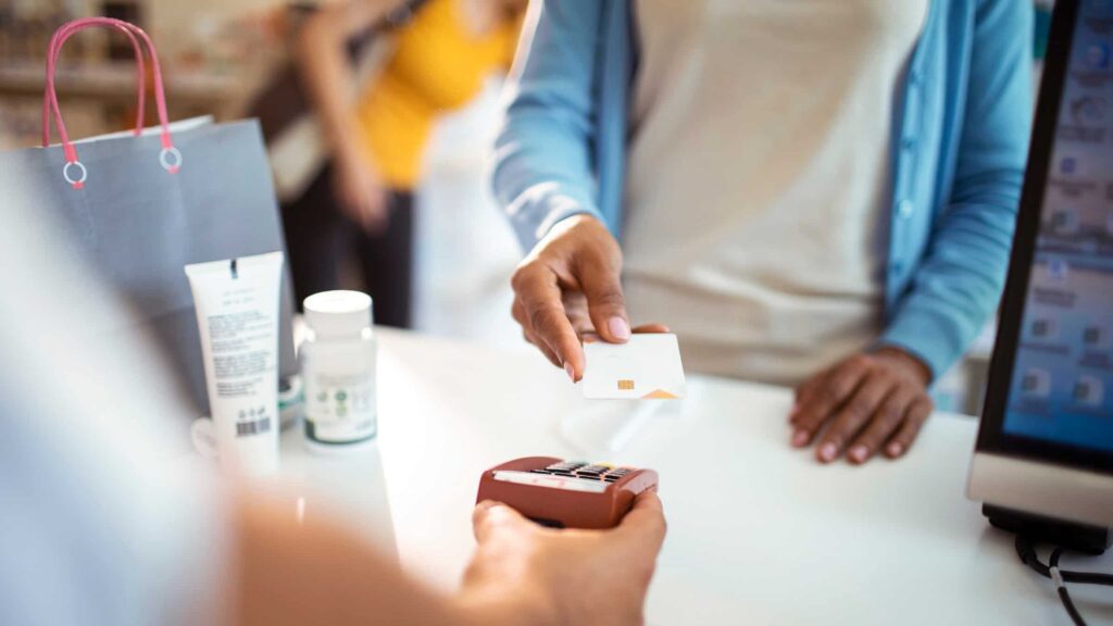 Person making a payment with a card at a store counter.