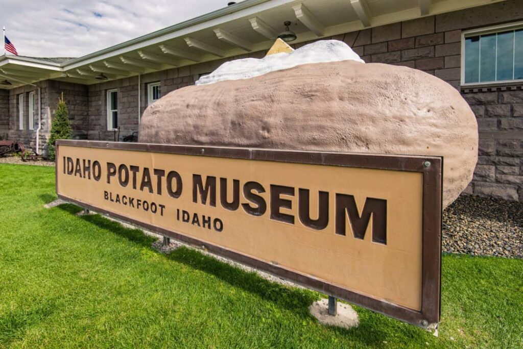 Sign for the Idaho Potato Museum in Blackfoot, Idaho, featuring a large potato sculpture with butter.