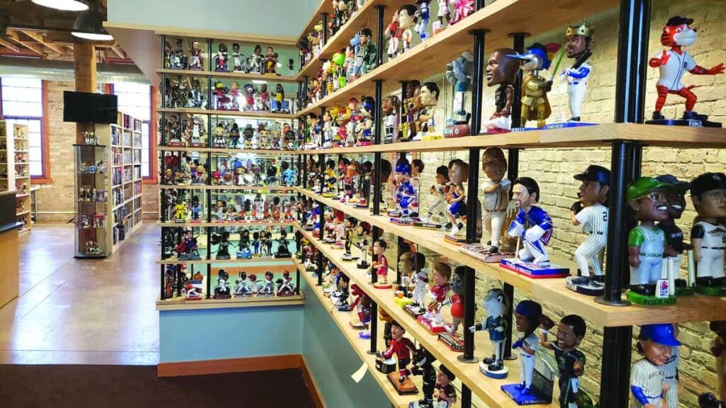 Shelves filled with various sports bobblehead figures in a store, showcasing baseball and other athletes.