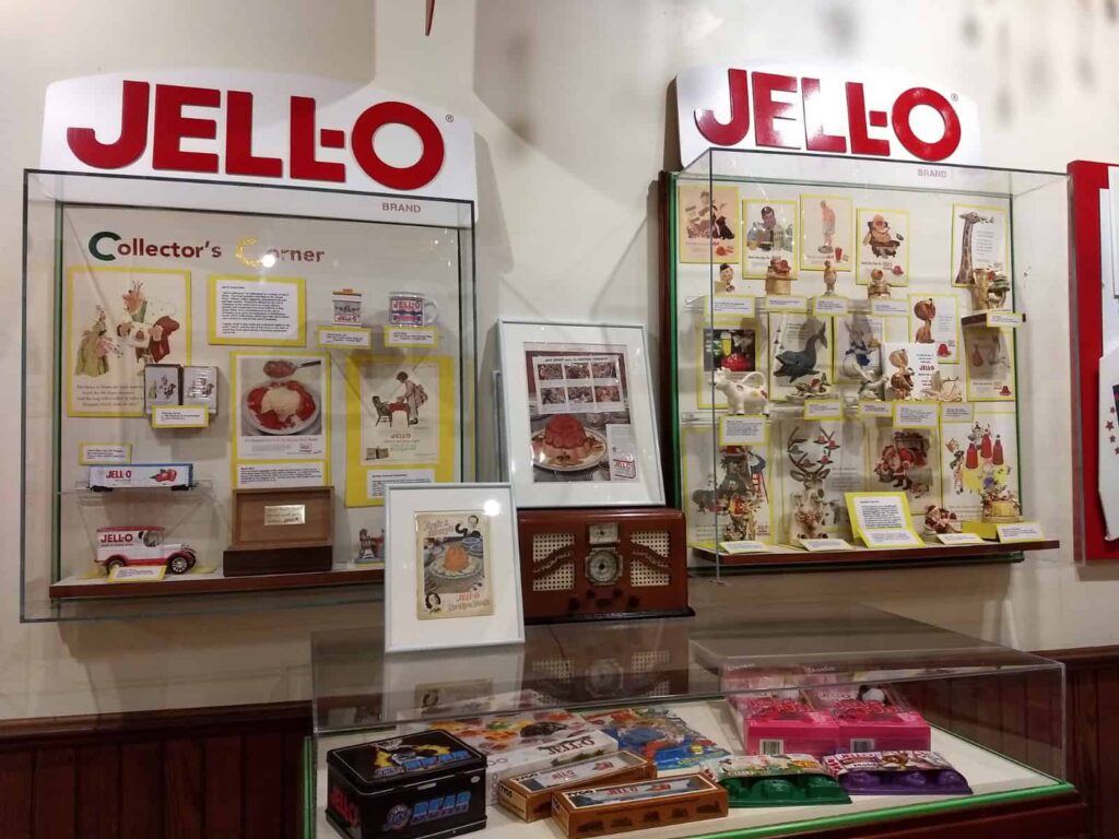 Display of Jell-O memorabilia, including recipe cards, vintage ads, and collectibles in glass cases at an exhibit.