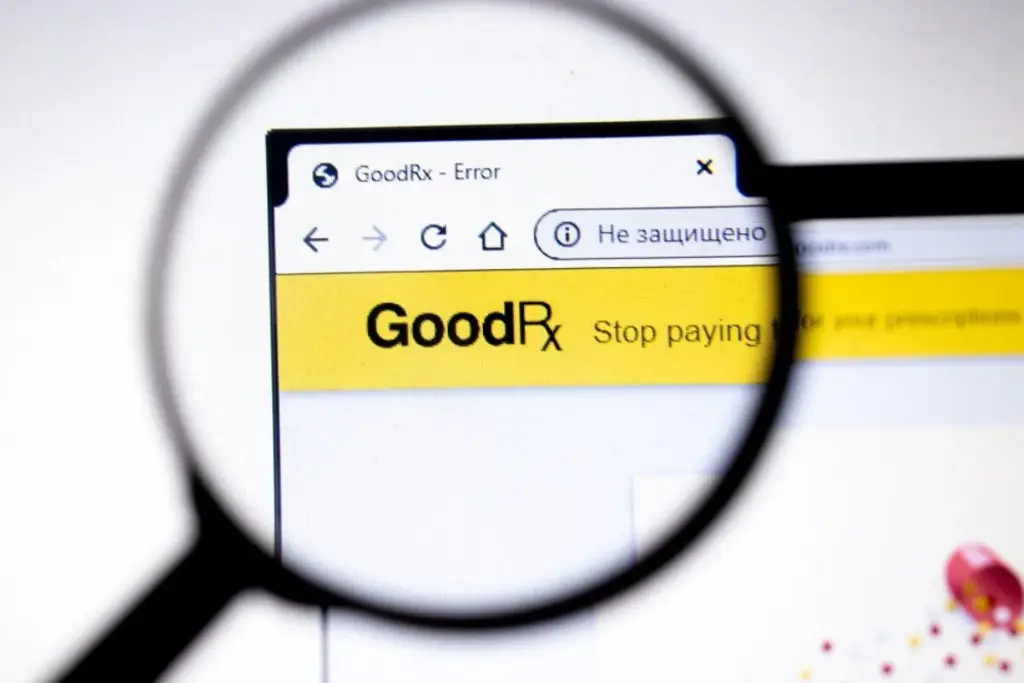 Magnifying glass focusing on a browser tab showing the GoodRx website with an error message on the screen.
