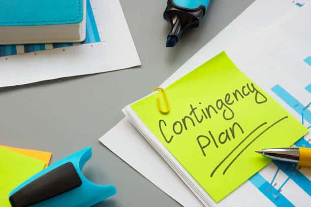 A desk with a sticky note labeled "Contingency Plan," highlighters, papers, and a pen.