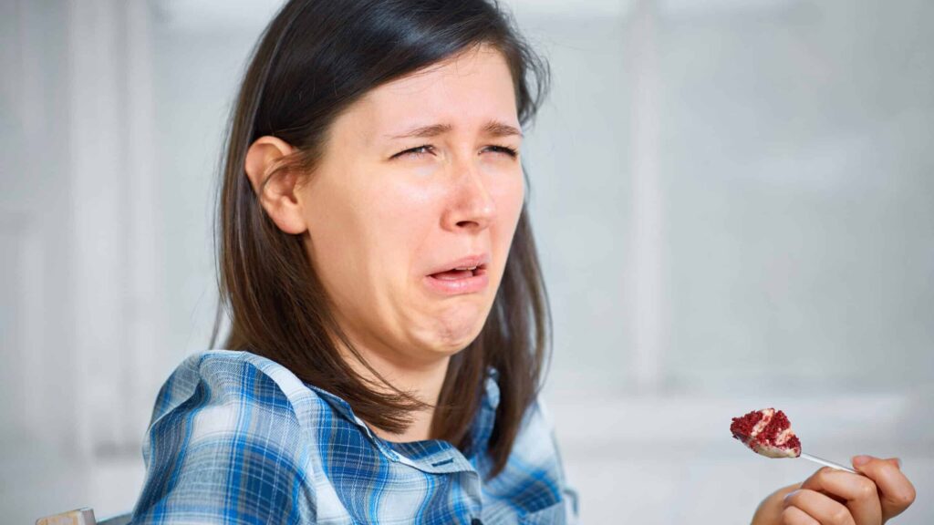 A woman grimacing questioning why healthy food sometimes tastes bad.